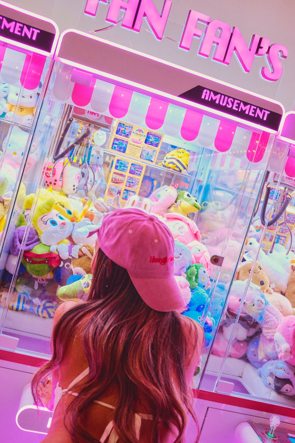 Back view of pink Hotgirlsauce hat worn in neon arcade setting