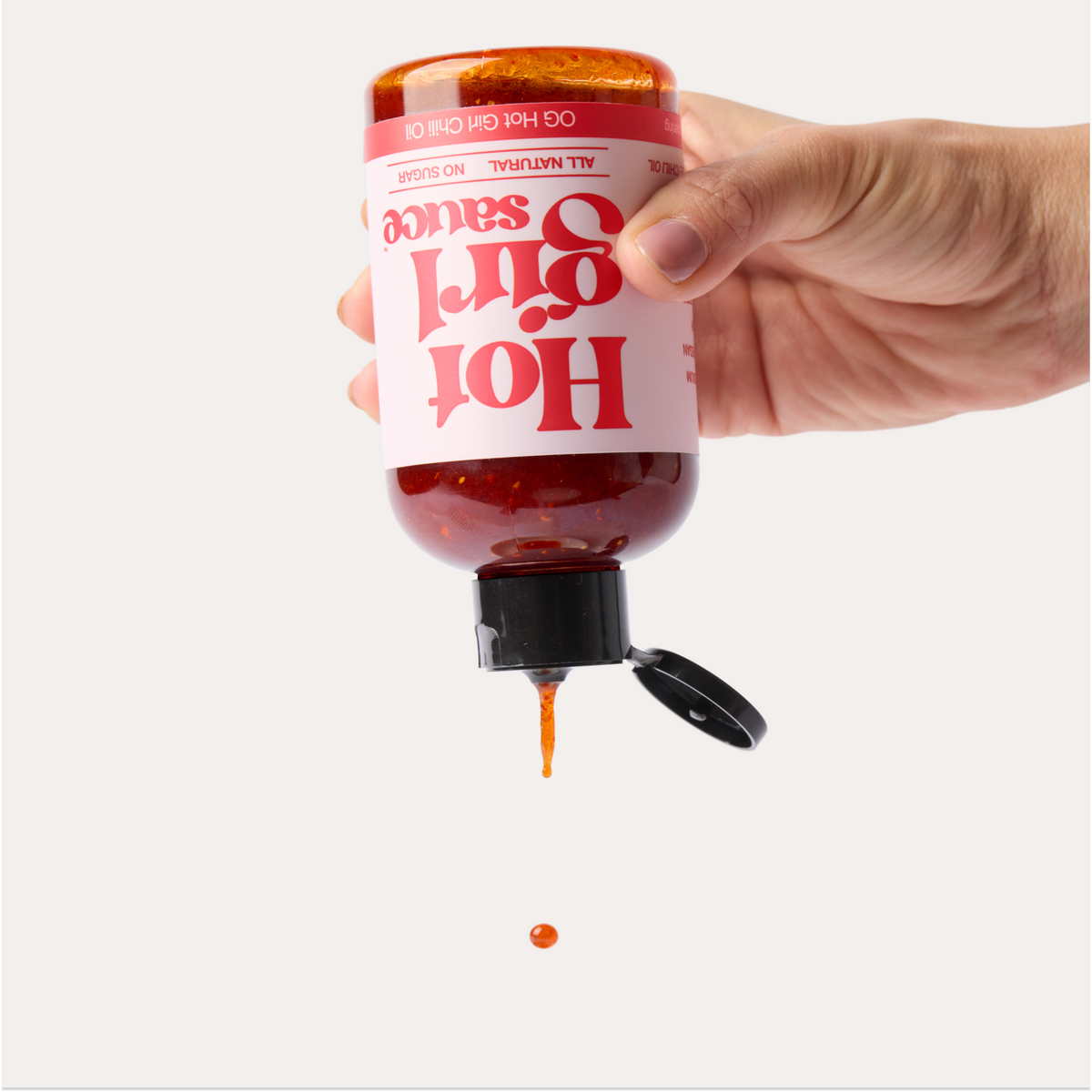 Silky smooth chili oil dripping from a bottle of OG Hot Girl Squeezable Chili Oil -  Hotgirlsauce chili oil - chili sauce - hot sauce