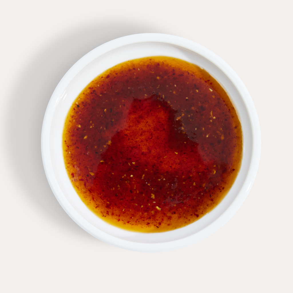Vibrant, silky smooth OG Hot Girl Chili Oil in a saucer - Hotgirlsauce chili oil - chili sauce - hot sauce